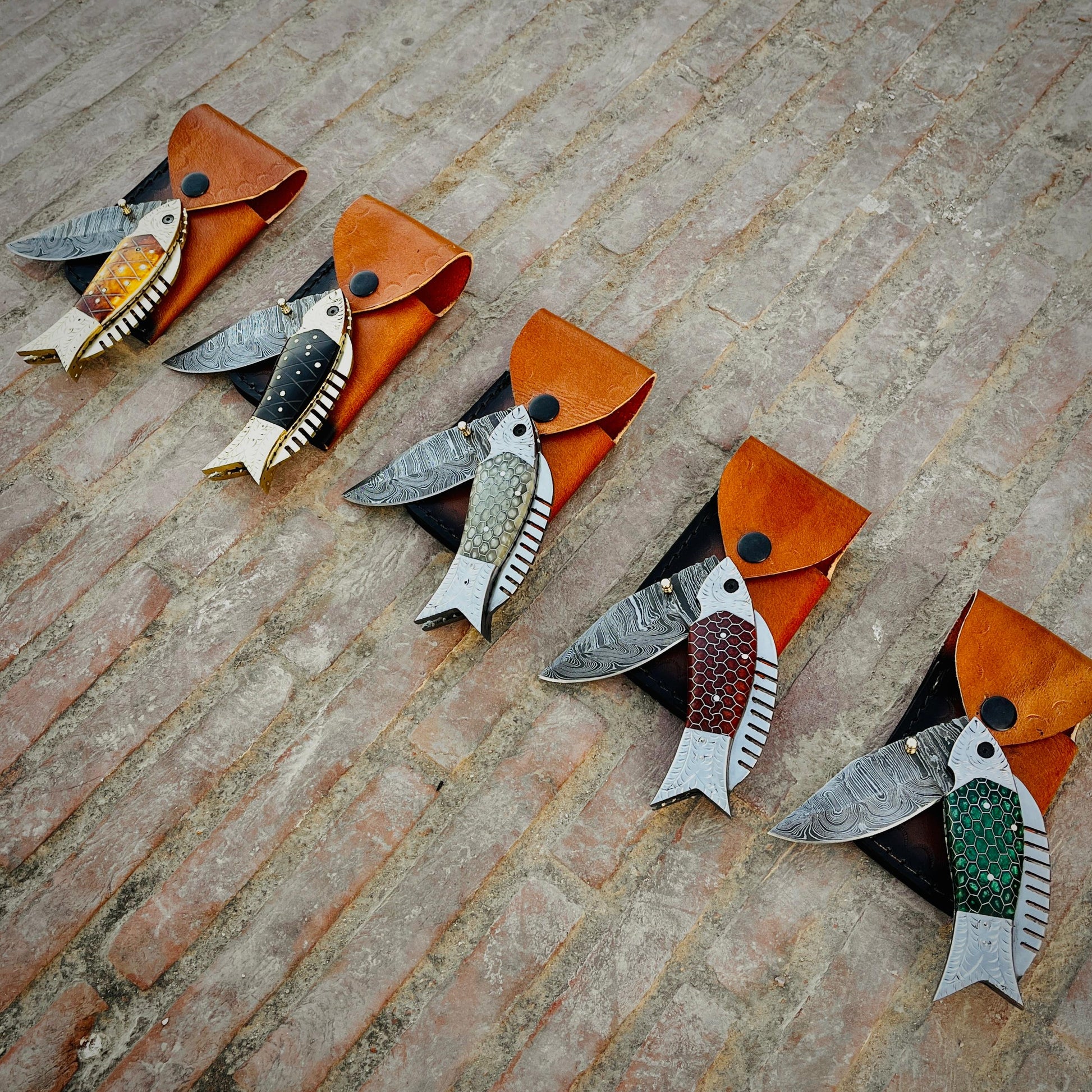 Fish shaped Damascus pocket knife with honeycomb handle design placed on leather pouch highlighting unique artistic knife craftsmanship.