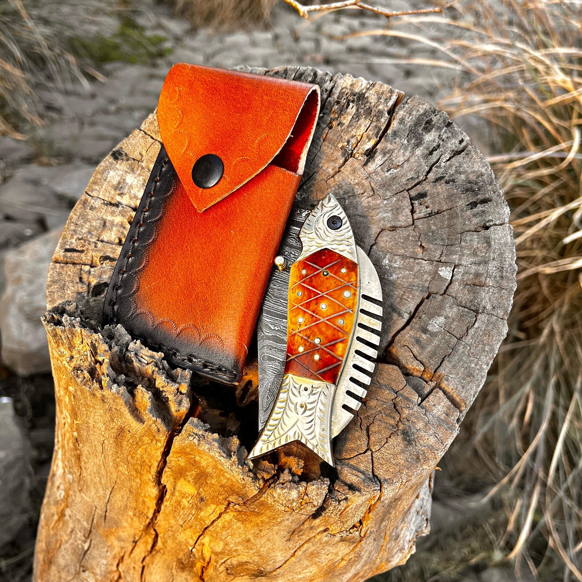 Leather sheath for Damascus pocket knife placed on wooden stump showing handcrafted leather texture and secure knife carrying option.
