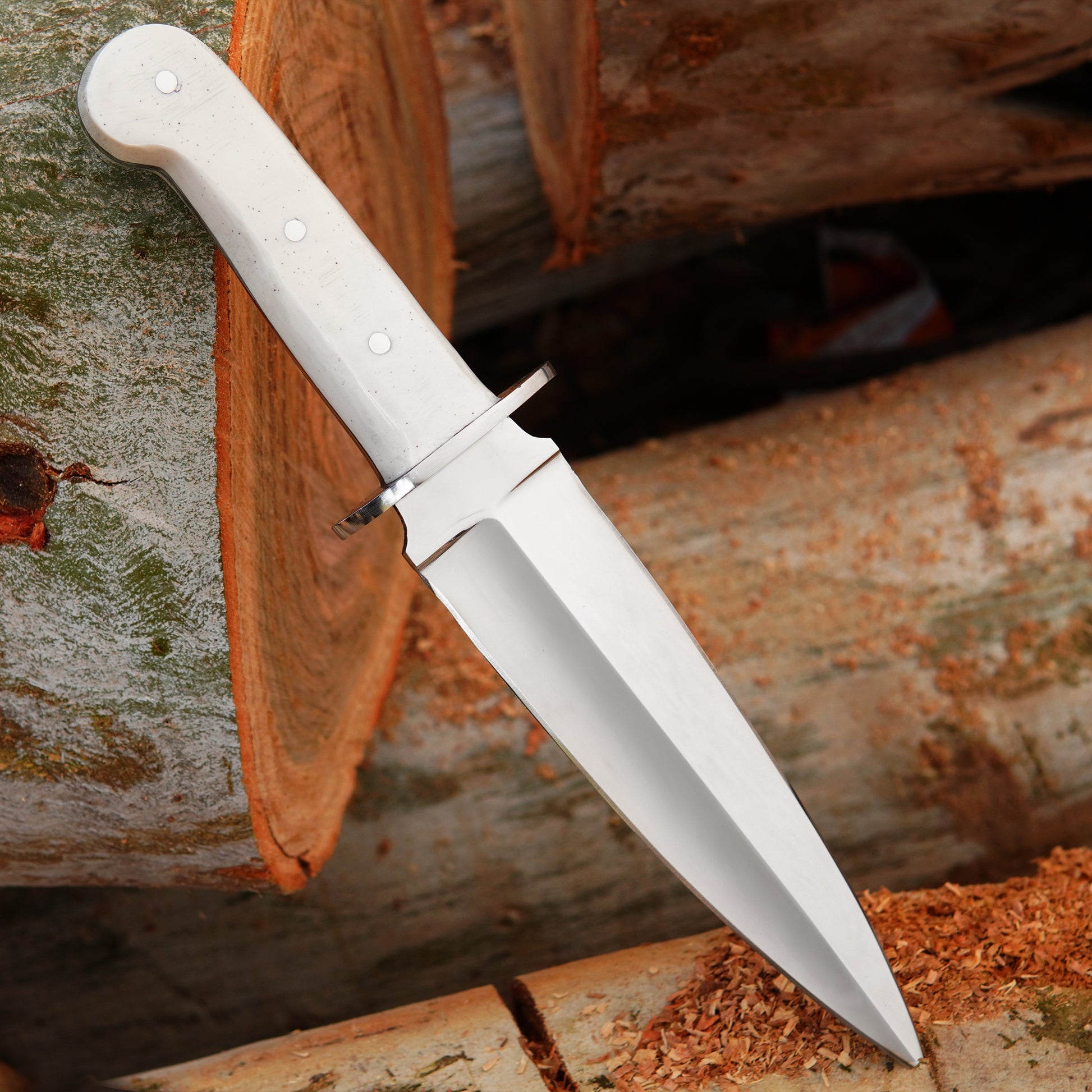 Handmade bowie knife with smooth white handle placed on natural wood background showing polished fixed blade and outdoor presentation suitable for camping and collectors looking for durable handcrafted knives with leather sheath included.