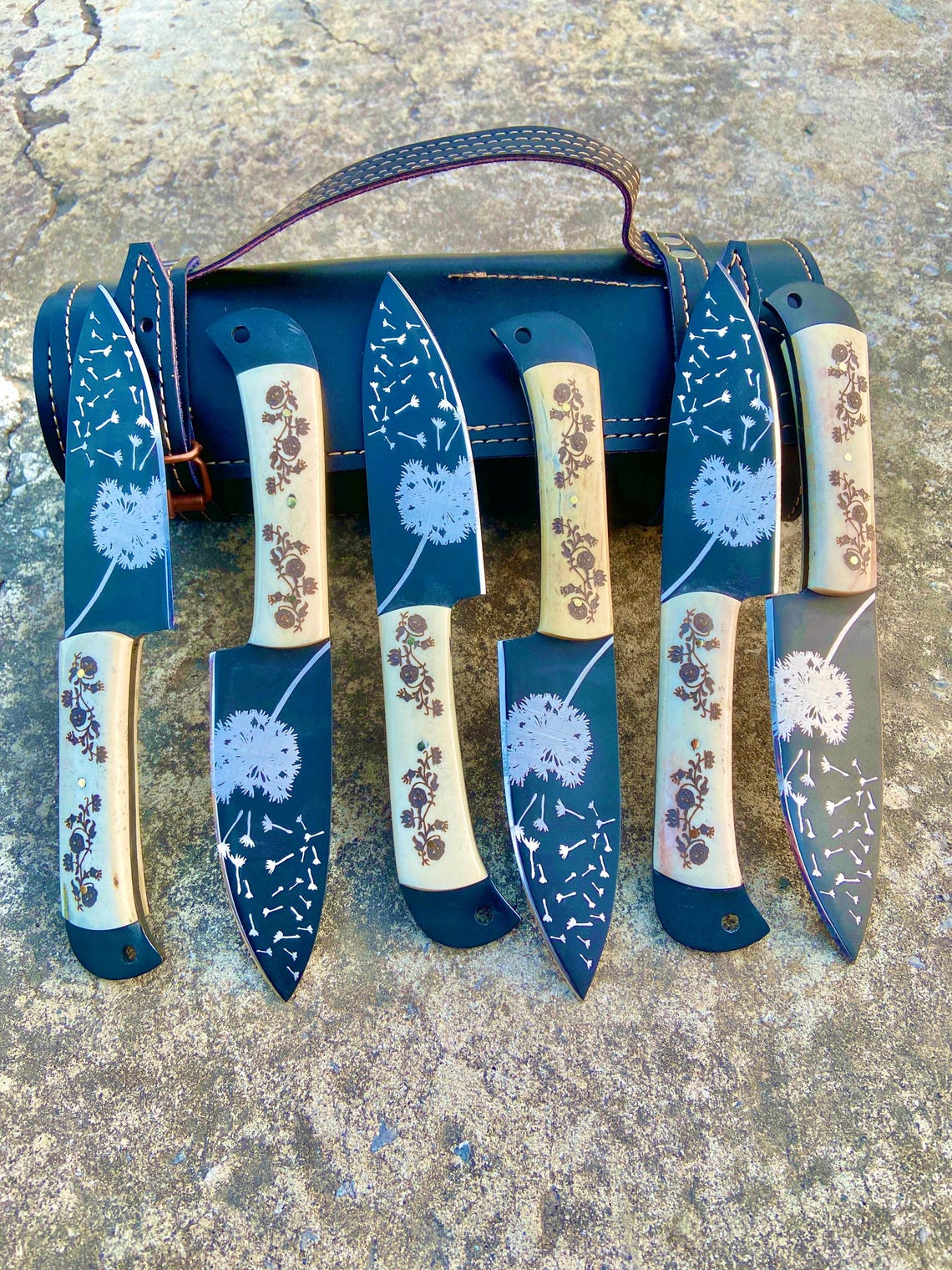 Artistic dandelion engraving on black coated knife blades of handmade steak knife set.