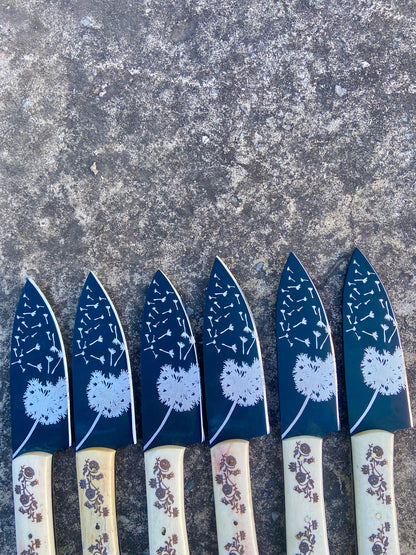 Floral engraved white handle knives laid on leather mat – ideal handmade gift for husband or mother.