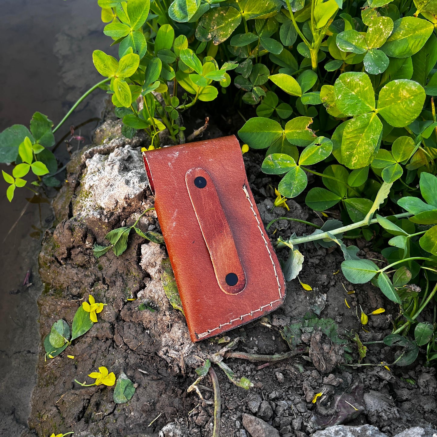 Black scale fish pocket knife with Damascus blade and engraved handle details shown with leather sheath.