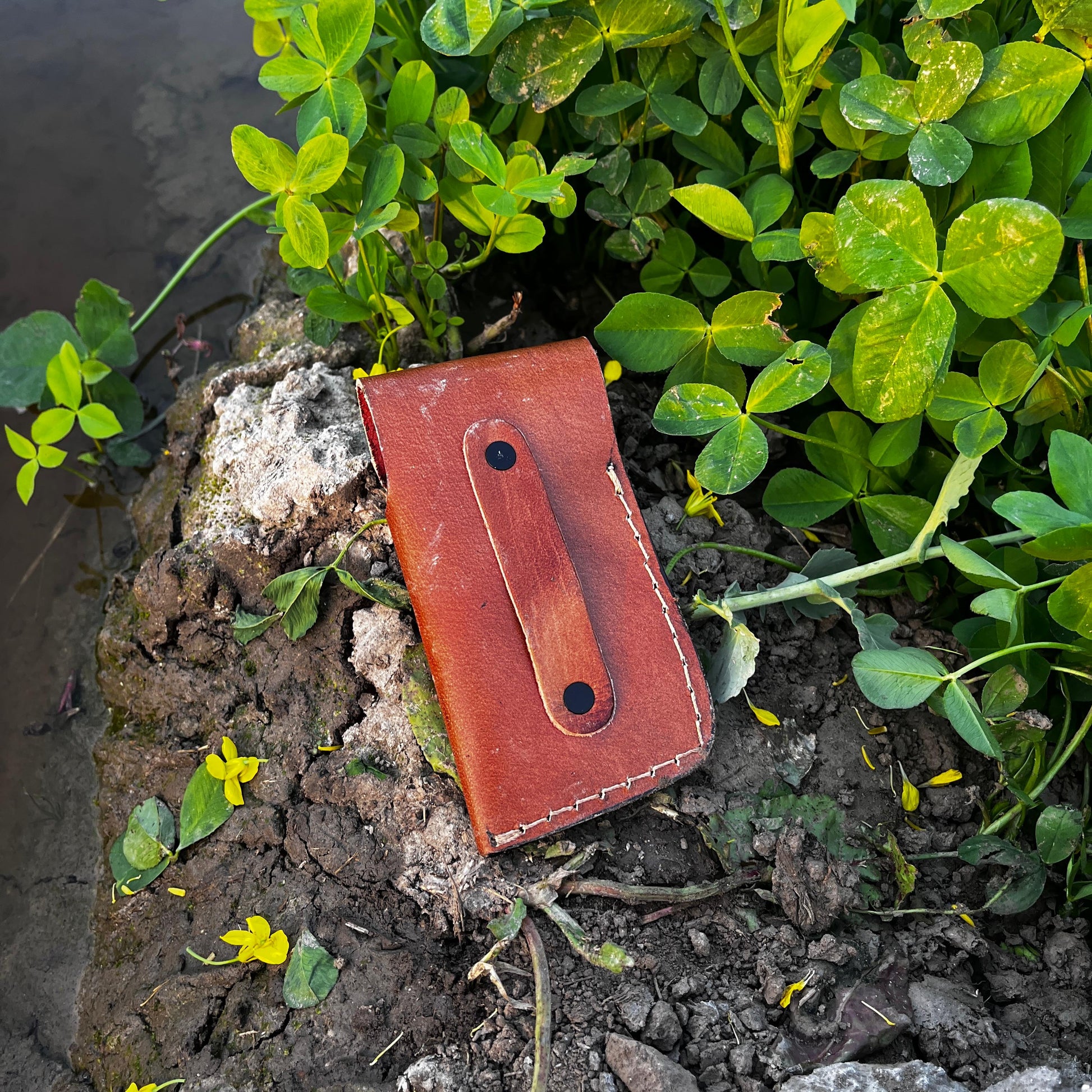 Black scale fish pocket knife with Damascus blade and engraved handle details shown with leather sheath.