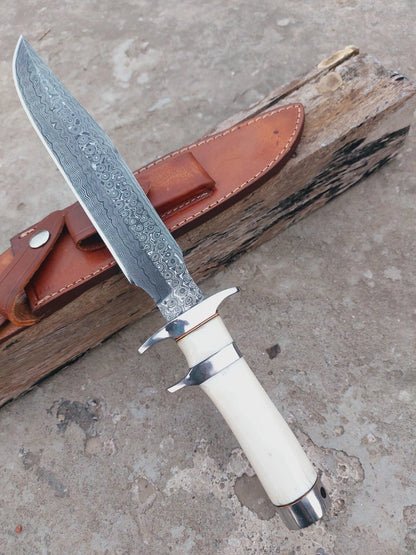 Unique handmade Damascus steel hunting knife crafted with bone handle, subhilt guard, and sharp patterned blade. Includes durable leather sheath. Perfect balance of artistry and practical outdoor use.
