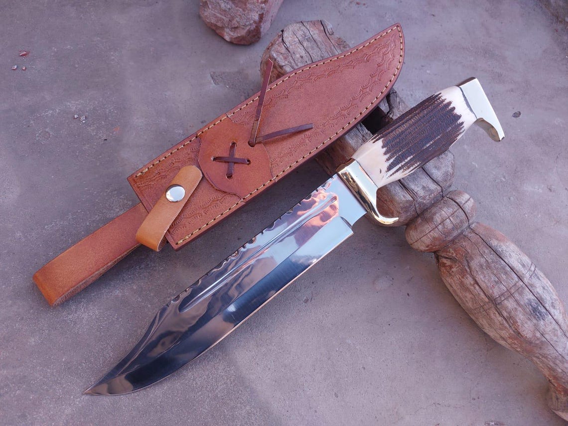 Detailed shot showing mirror finish and spine pattern of the carbon steel Bowie blade.