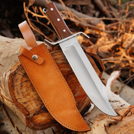 Handmade carbon steel Bowie knife with satin finished blade placed on rustic wooden background.