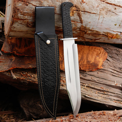 Handmade bowie knife with black textured handle placed on natural wood background showing full tang construction and clean blade finish suitable for outdoor camping bushcraft and collectors looking for durable handmade carbon steel knife with leather sheath for safe carry and long term use.