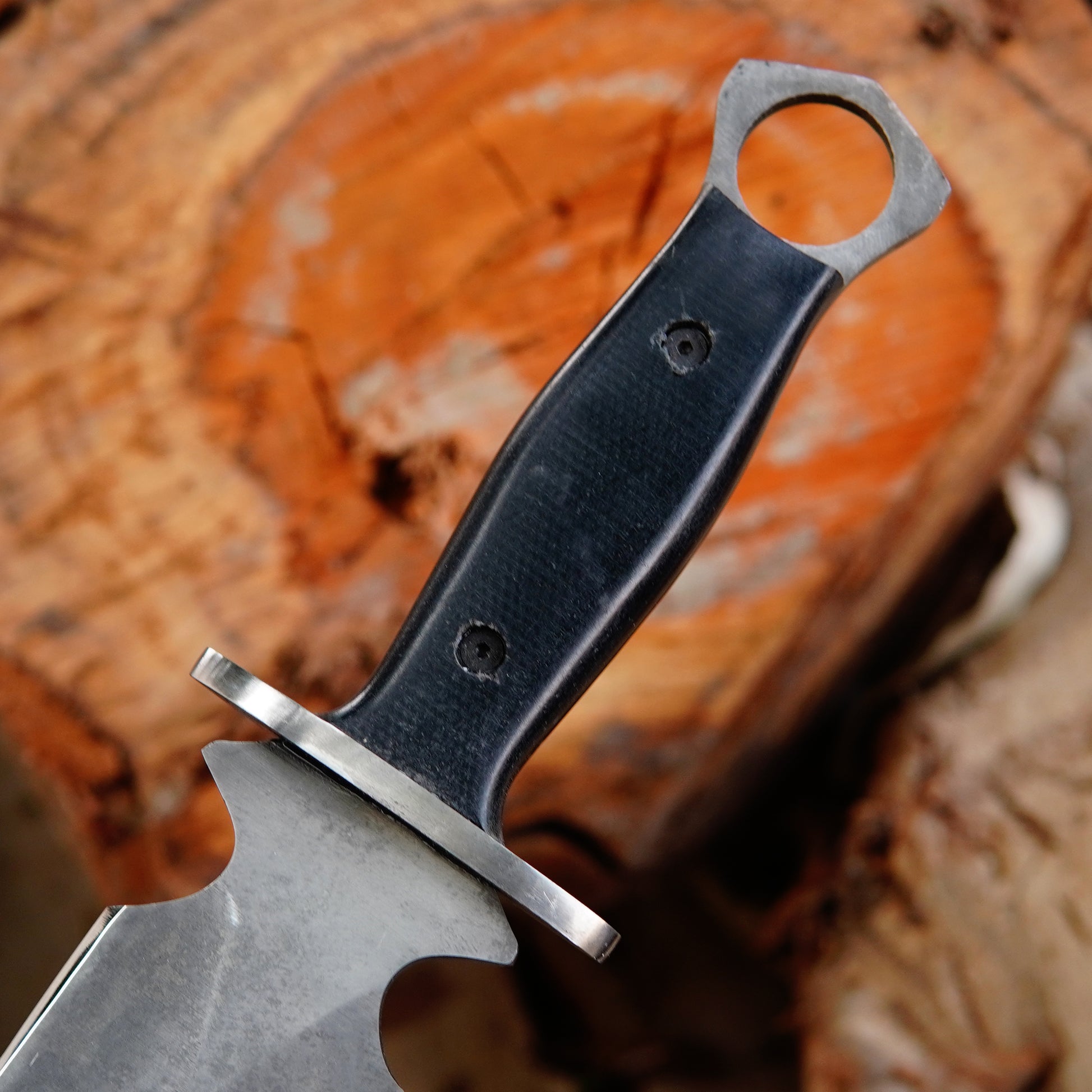 Black leather sheath with reinforced stitching and rivets for secure knife carrying.