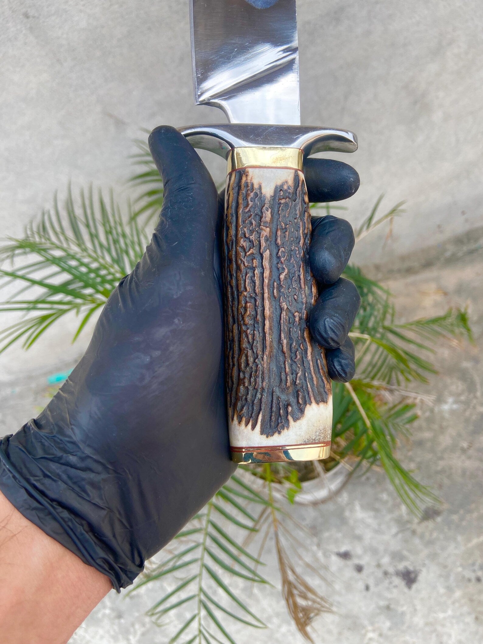 Handmade carbon steel Bowie knife with red-brown leather sheath, crafted for hunters and collectors.