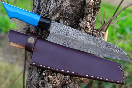 A hand forged chef knife made from Damascus steel with a glossy blue resin handle. Sharp, durable, and unique, this knife is ideal for cooking at home, BBQ, or outdoor use. A thoughtful gift option with free engraving available.