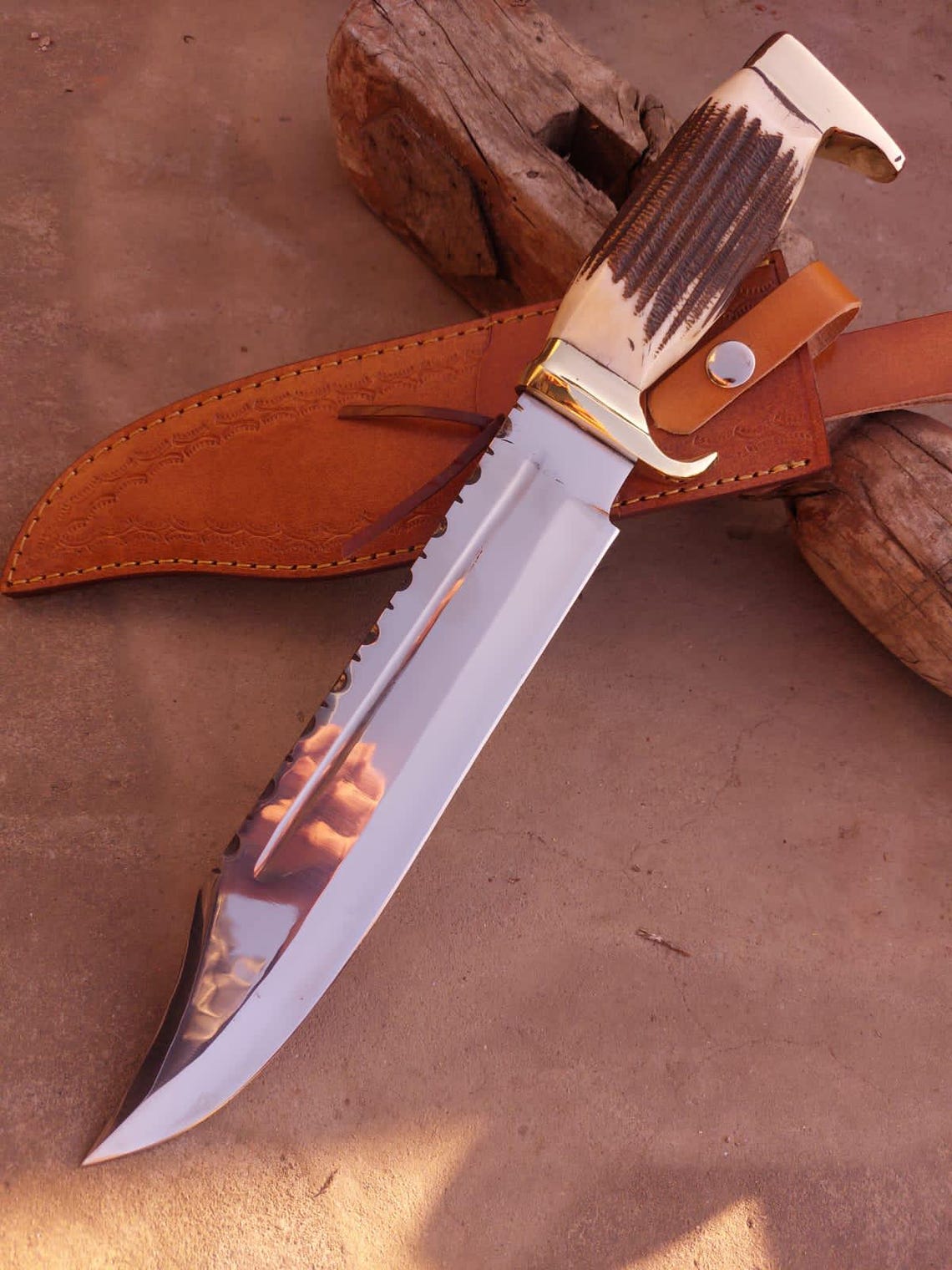 Polished brass guard and pommel detail of handmade Bowie knife with stag handle.