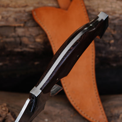 Handmade outdoor knife placed on natural wooden surface highlighting blade curvature and balanced design. The image captures the rugged outdoor feel while maintaining a clean and premium presentation, ideal for showcasing craftsmanship and functional design in product listings.