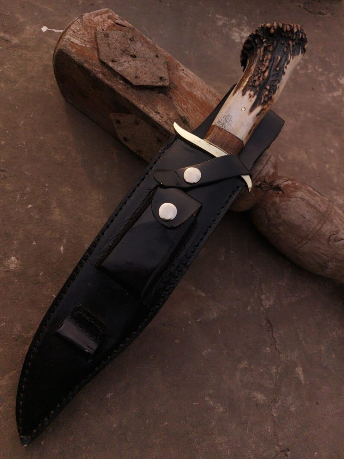 Close-up of Bowie knife showing mirror-finished carbon steel blade and hand-crafted stag handle.