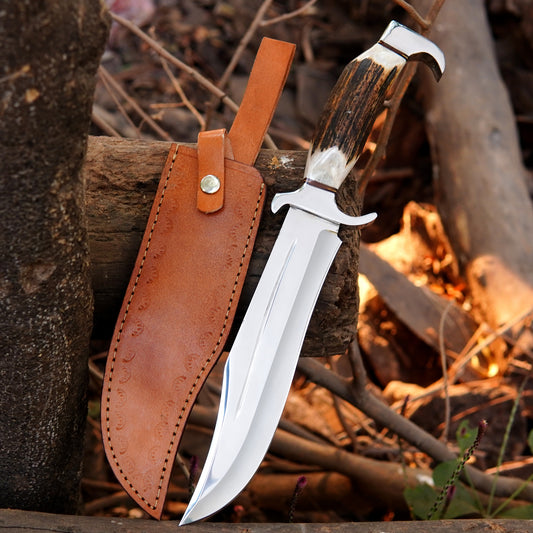 Handmade carbon steel Bowie knife with mirror polished clip point blade displayed on rustic wooden background.