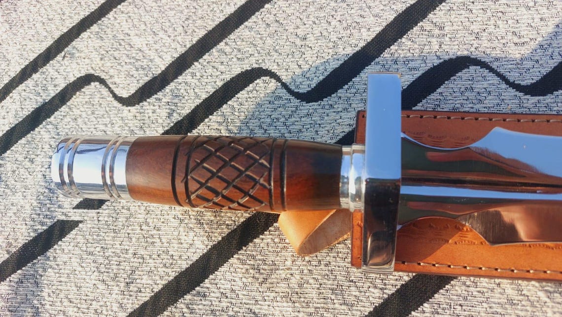 Wooden handle dagger knife showing carved grip and balanced design.