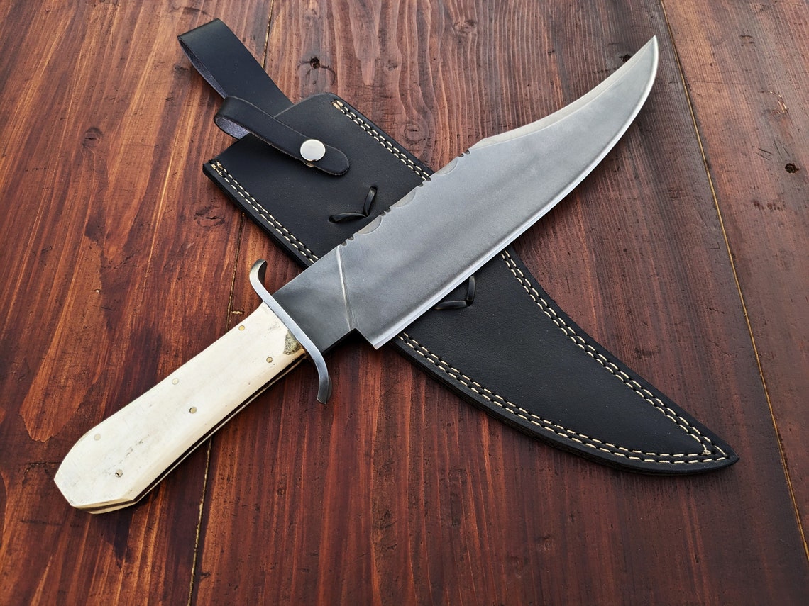 Handmade Alamo Musso Bowie knife crafted from high carbon steel with a full tang design, featuring a smooth polished camel bone handle and satin-finished blade. Includes a premium black leather sheath for safe carry and display, perfect for collectors, hunters, and survival use.
