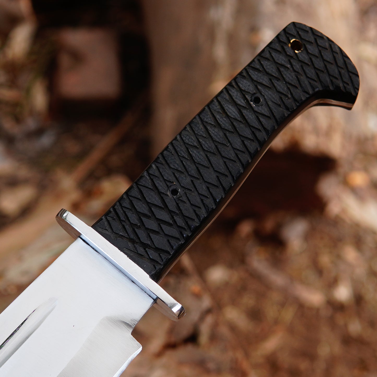 Outdoor display image of handmade bowie knife placed on natural wood emphasizing rugged design strong blade and practical outdoor appearance making it suitable for camping gear collection outdoor adventures and gift purposes.
