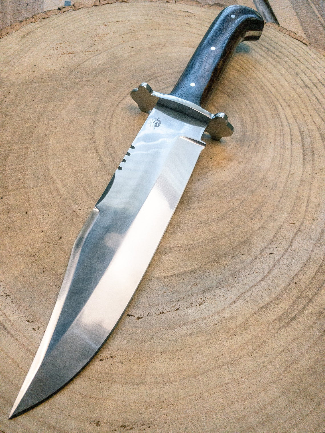 Full tang handmade Bowie knife for outdoor survival and hunting. Features a polished carbon steel blade with an elegant wooden handle, combining durability with a stylish handcrafted finish.