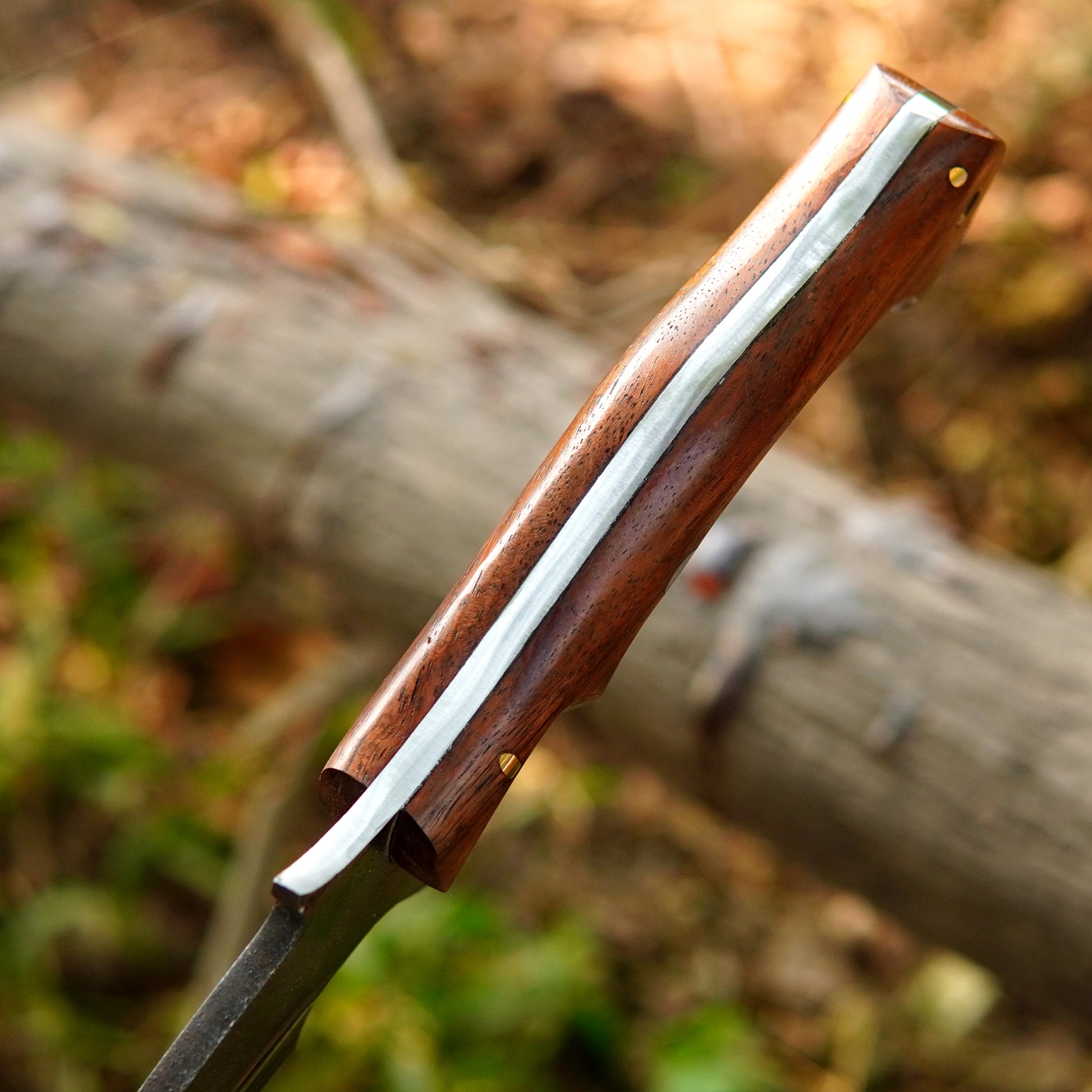 Close-up of a polished steel blade bowie knife showing clean lines and refined finish.