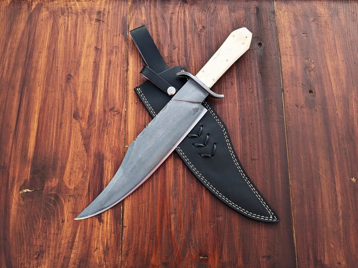 Hand-forged Bowie knife with 11.5-inch carbon steel blade and camel bone handle, showing clean craftsmanship and outdoor-ready construction for performance use.