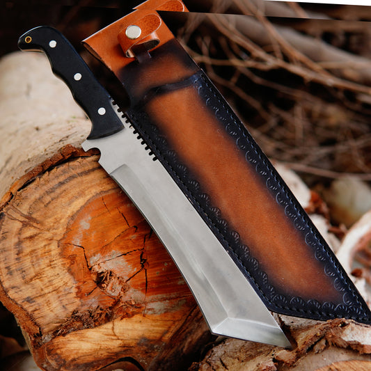 Handmade bowie knife displayed outdoors on natural wood surface showing full tang carbon steel blade and ergonomic handle design with leather sheath placed beside the knife highlighting craftsmanship and outdoor usability suitable for camping and collection purposes.