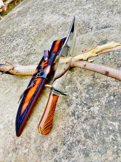 Detailed image of handmade carbon steel Bowie knife with smooth rosewood handle and hand-stitched brown leather sheath. The combination of steel guard and mirror polish offers both elegance and toughness, ideal for collectors or outdoor use.