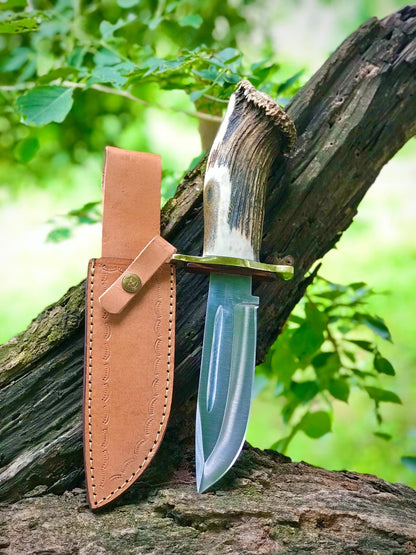 Handmade Bowie knife with a natural stag handle and leather sheath, presented as a hunting and camping knife for collectors and outdoor enthusiasts. A thoughtful Father’s Day or birthday gift for hunters, adventurers, and traditional knife lovers.