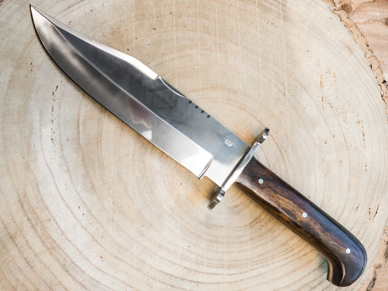 Mirror-polished carbon steel Bowie knife with smooth wooden handle and classic design, handcrafted for outdoor adventures, camping, or gifting to knife enthusiasts. Includes a durable leather sheath for protection.