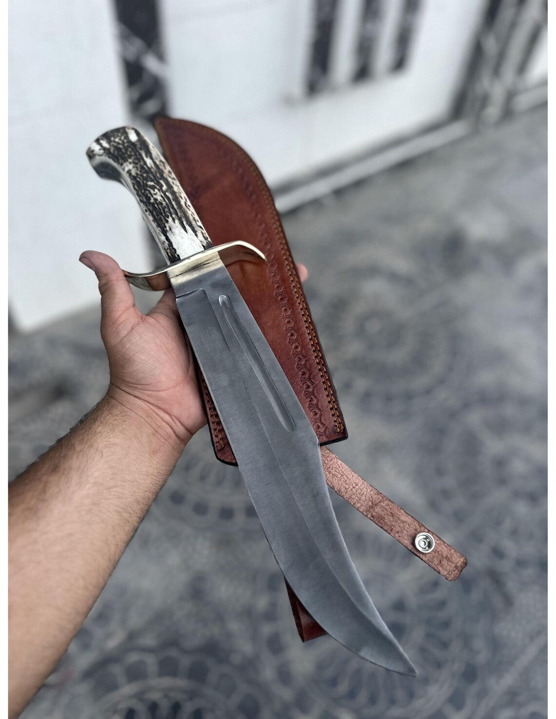 Side view of handmade Bowie knife with full tang construction and polished finish.