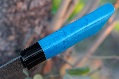A handmade chef knife with a Damascus steel blade and blue resin handle. Strong and attractive, this cleaver-style knife is suited for kitchen chopping, BBQ prep, and outdoor cooking. Free engraving included to personalise it.