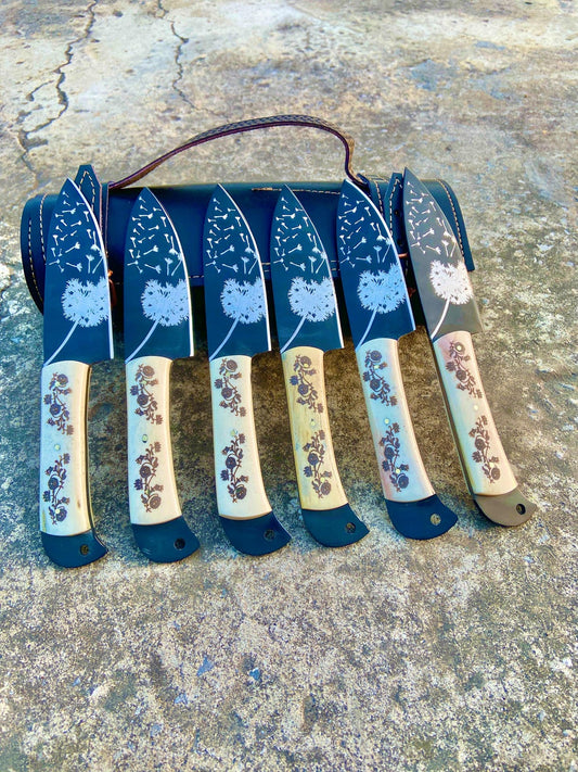 Handmade 6-piece floral engraved steak knife set with black carbon steel blades and white handles in a premium leather roll.
