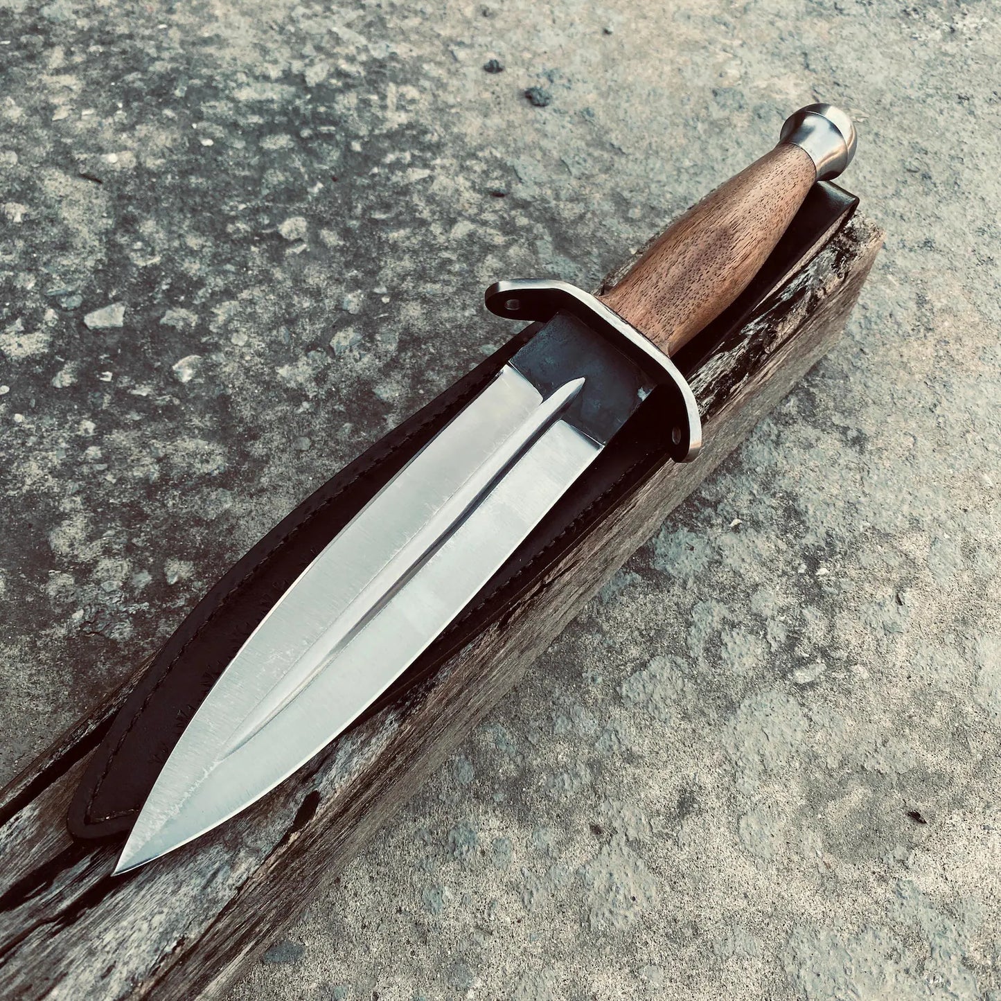 Handmade double-edge dagger knife crafted from 1095 carbon steel with a wooden handle.