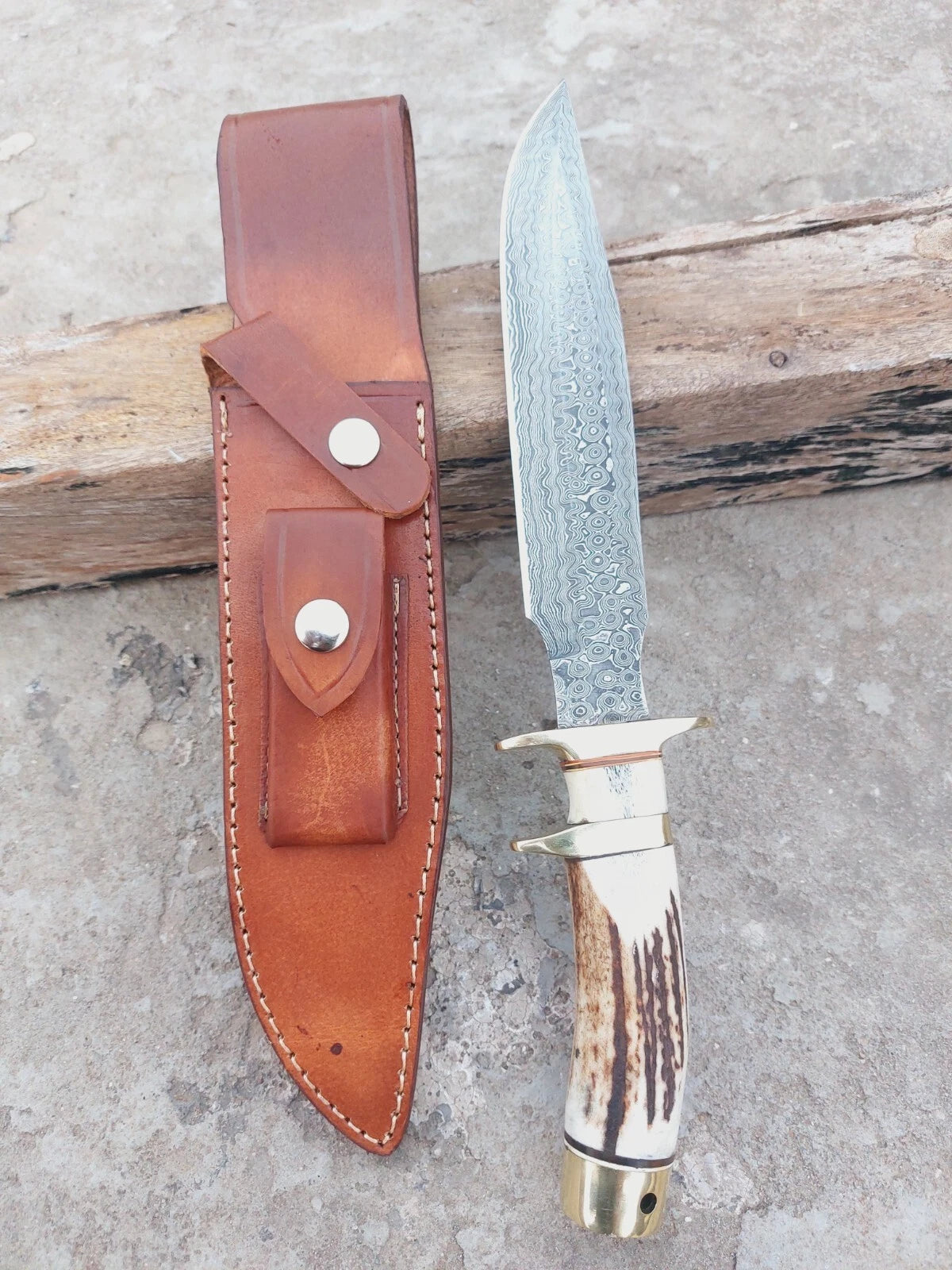 Outdoor Damascus hunting knife featuring subhilt grip, stag handle, and brass fittings. Comes with a hand-stitched leather sheath. This handmade knife is durable, sharp, and designed for real use as well as collectible value.