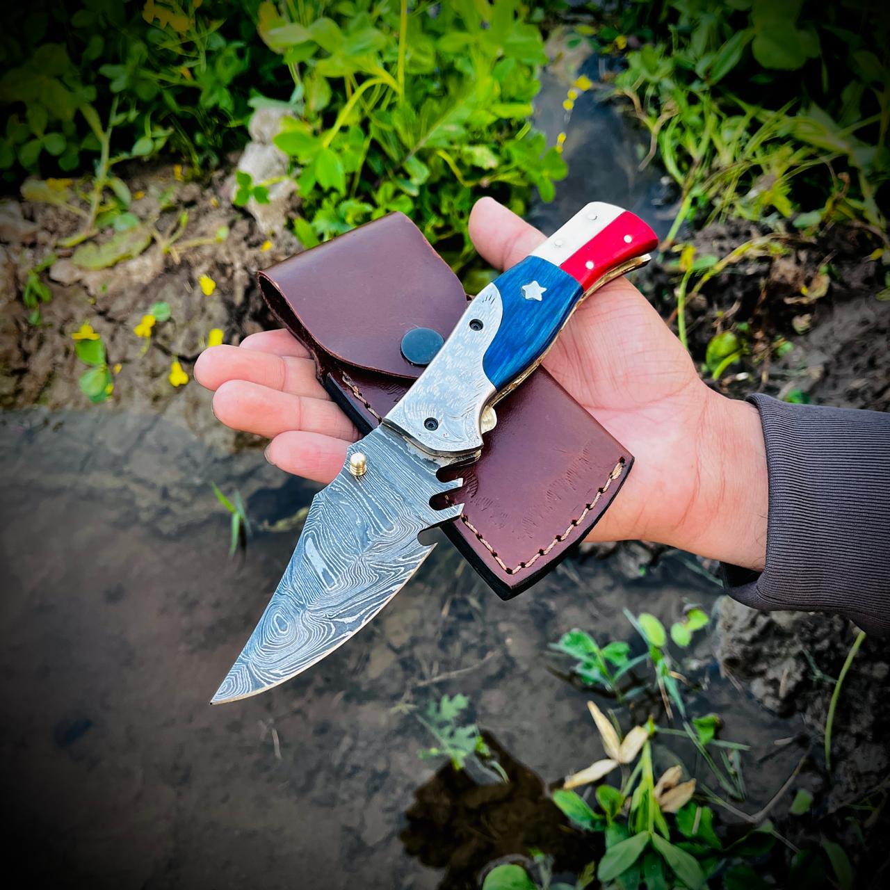 Handmade Damascus EDC pocket knife open blade view highlighting patterned steel and folding mechanism.