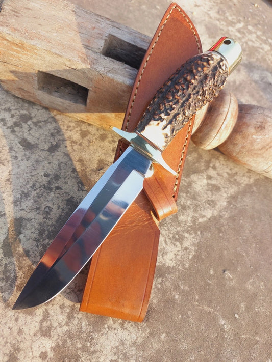Custom handmade hunting knife featuring a popcorn stag handle with natural grip texture, paired with a razor-sharp fixed blade. Includes a hand-stitched leather sheath for safe carrying and storage. Perfect for camping, hunting, and outdoor use, this knife offers both practicality and traditional craftsmanship in one unique design.