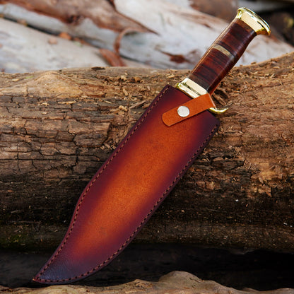 Detailed image of the handle featuring a stacked layered design in rich brown tones, complemented by polished brass guard and pommel. The ergonomic grip provides comfort and control during use, while the premium finish gives the knife a classic and timeless appearance. This handcrafted hunting knife is not only functional but also a beautiful collectible piece that makes a thoughtful gift for husbands, fathers, or outdoor enthusiasts.