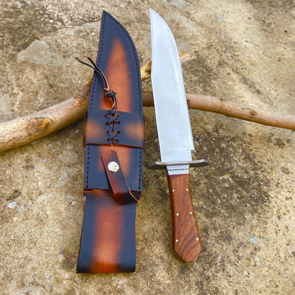 Handmade high-polished carbon steel Bowie knife with rosewood coffin handle and detailed leather sheath. The mirror finish on the blade reflects craftsmanship and strength, while the full tang construction provides durability and balance. Perfect for collectors, hunters, and outdoor enthusiasts looking for a premium handmade knife.