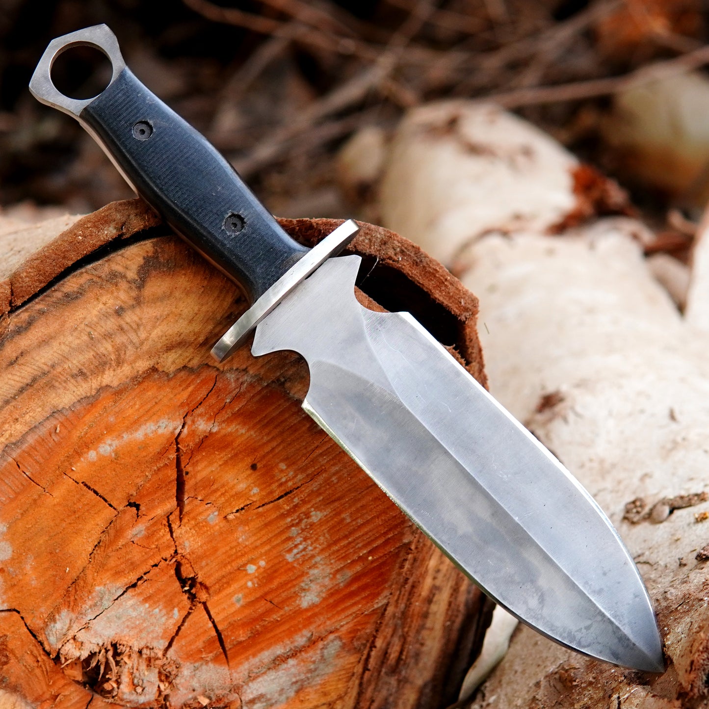 Full tang hunting knife with black micarta handle designed for outdoor survival use.