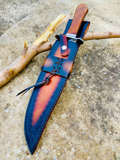 Close shot of the rosewood coffin handle on a handmade high-polished carbon steel Bowie knife. Brass pins and a full tang build ensure durability and a comfortable grip. The perfect balance of design, function, and traditional craftsmanship.