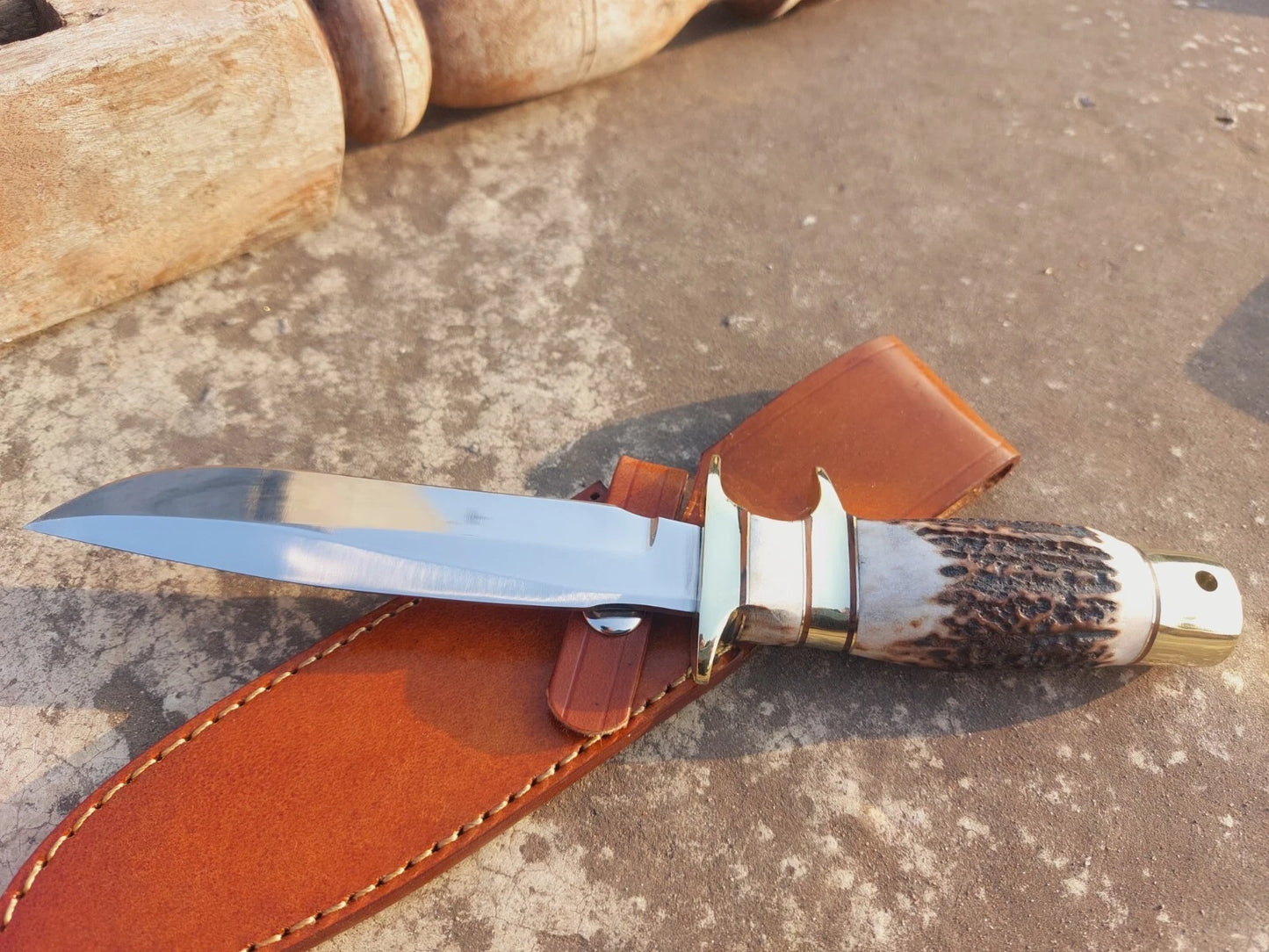 Subhilt hunting knife with polished carbon steel blade, brass fittings, and natural handle grip. The knife includes a premium stitched leather sheath, offering both beauty and functionality. Perfect for hunters and collectors seeking a handmade, durable knife.