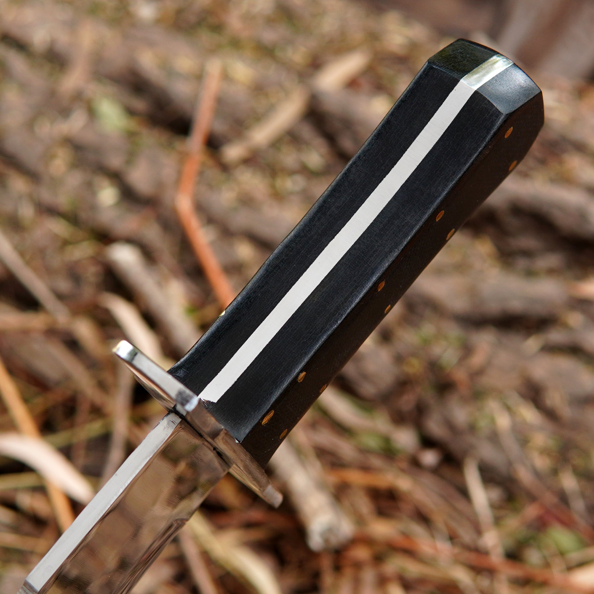 Close-up of a polished steel blade bowie knife with clean lines and refined finish.