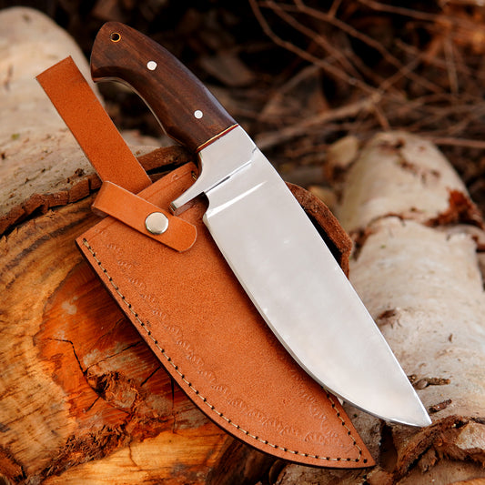 Handmade outdoor knife with polished steel blade, wooden handle, and premium leather sheath displayed on natural wood.