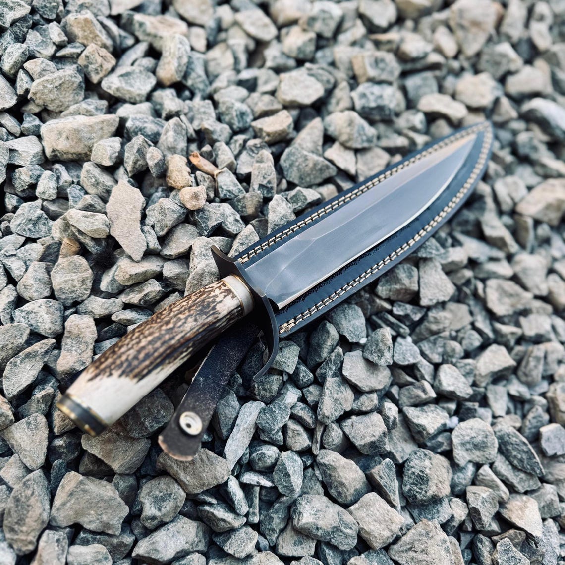 Full tang handmade hunting Bowie knife forged from 5160 spring steel, with ergonomic stag handle and rugged leather sheath for durability and timeless appeal.