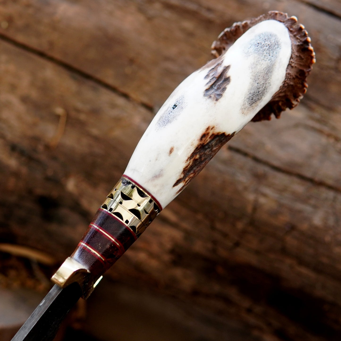 Full length outdoor display of handmade bowie knife resting on wooden background highlighting long blade profile and full tang construction. This image supports SEO keywords related to survival style knives, camping tools, and handmade outdoor equipment designed for durability and performance.