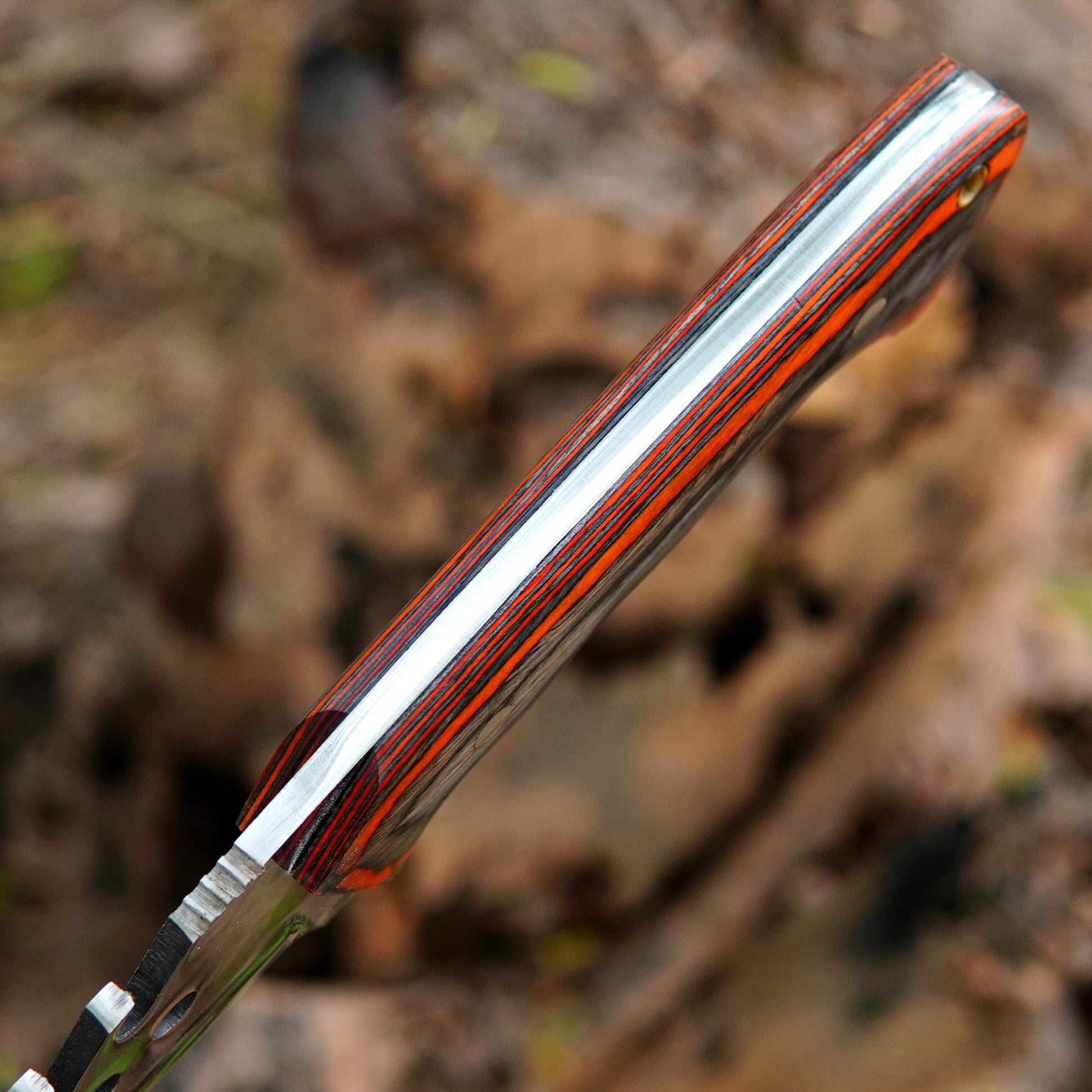 Handmade knife resting inside a pure leather sheath with strong stitching and snap strap closure for safe belt carry. Ideal for outdoor adventures and everyday field use.