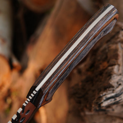 Detailed blade close-up showing high carbon steel surface and spine design of handmade bowie knife. The image emphasizes craftsmanship, durability, and balanced construction while highlighting the practical outdoor use of the knife for bushcraft and camping environments with a strong visual presentation.
