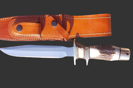 Carbon steel fixed blade hunting knife with stag antler handle, mirror polished finish, and brass fittings. Comes with a hand stitched genuine leather sheath for safe carry. Designed for hunters, campers, and outdoor enthusiasts who value craftsmanship and reliability.