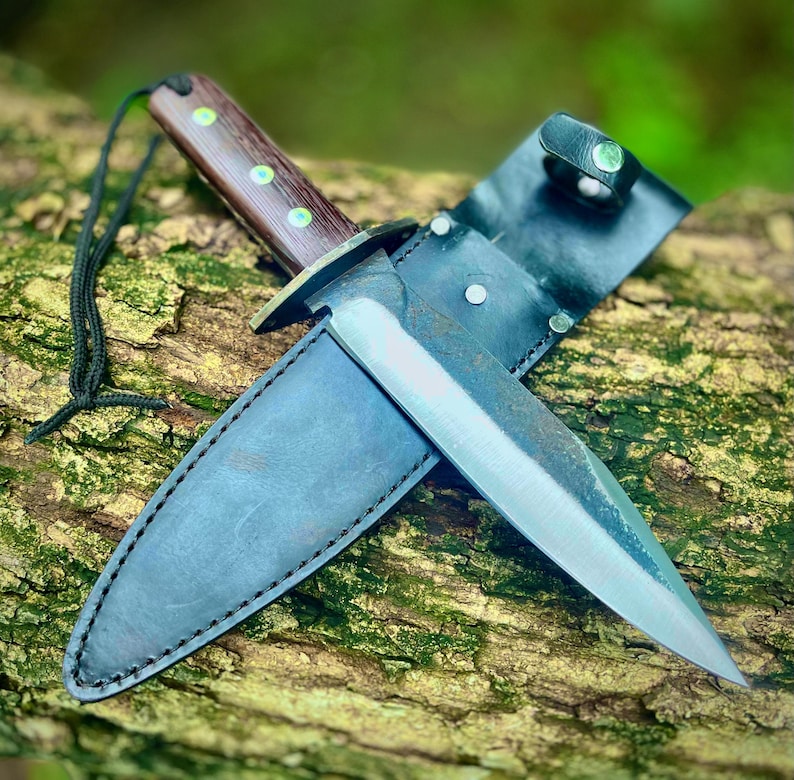 Handmade full tang carbon steel hunting knife and sheath set on a natural wood background.