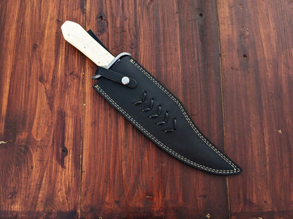 Custom handmade full tang Musso Bowie knife with double guard, smooth edge, and stitched leather sheath for secure carry and long-lasting protection.