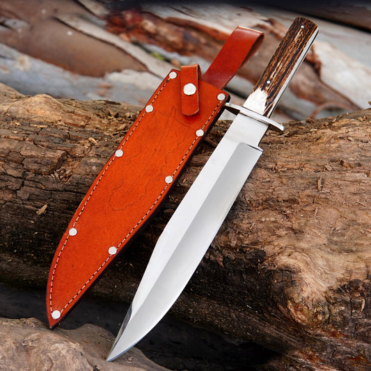 Handmade full tang Bowie knife with satin polished carbon steel blade displayed on rustic wooden logs.